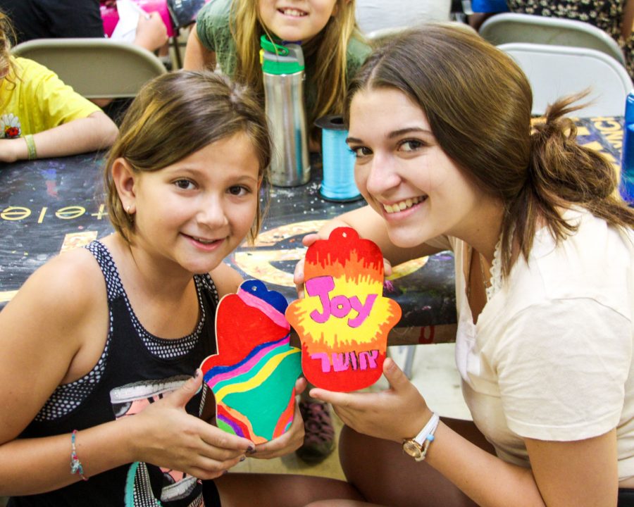 Camper and counselor making arts and crafts together