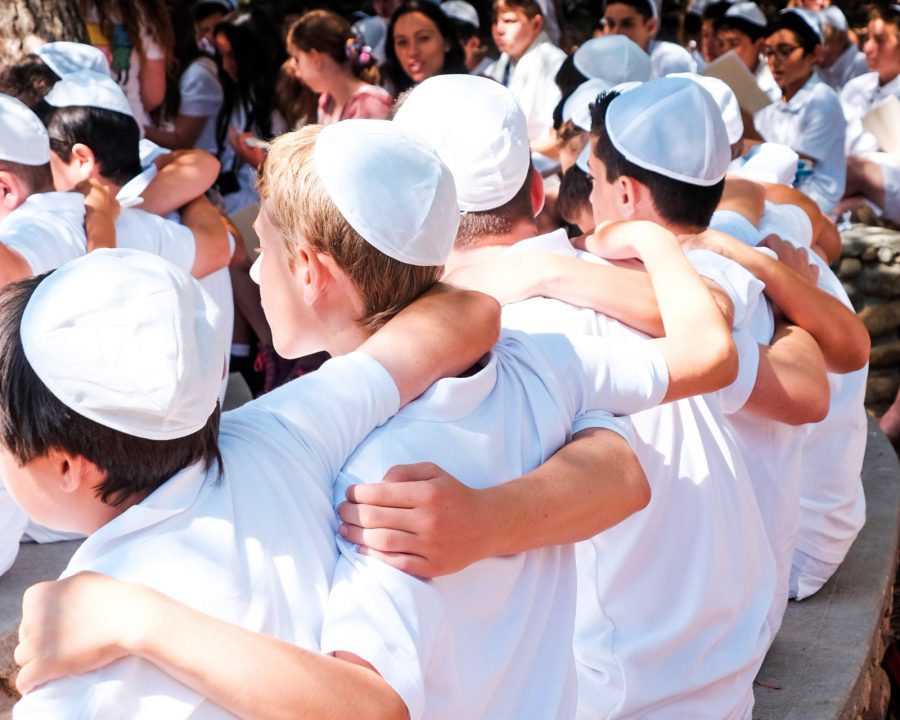 Campers in white with arms around each other