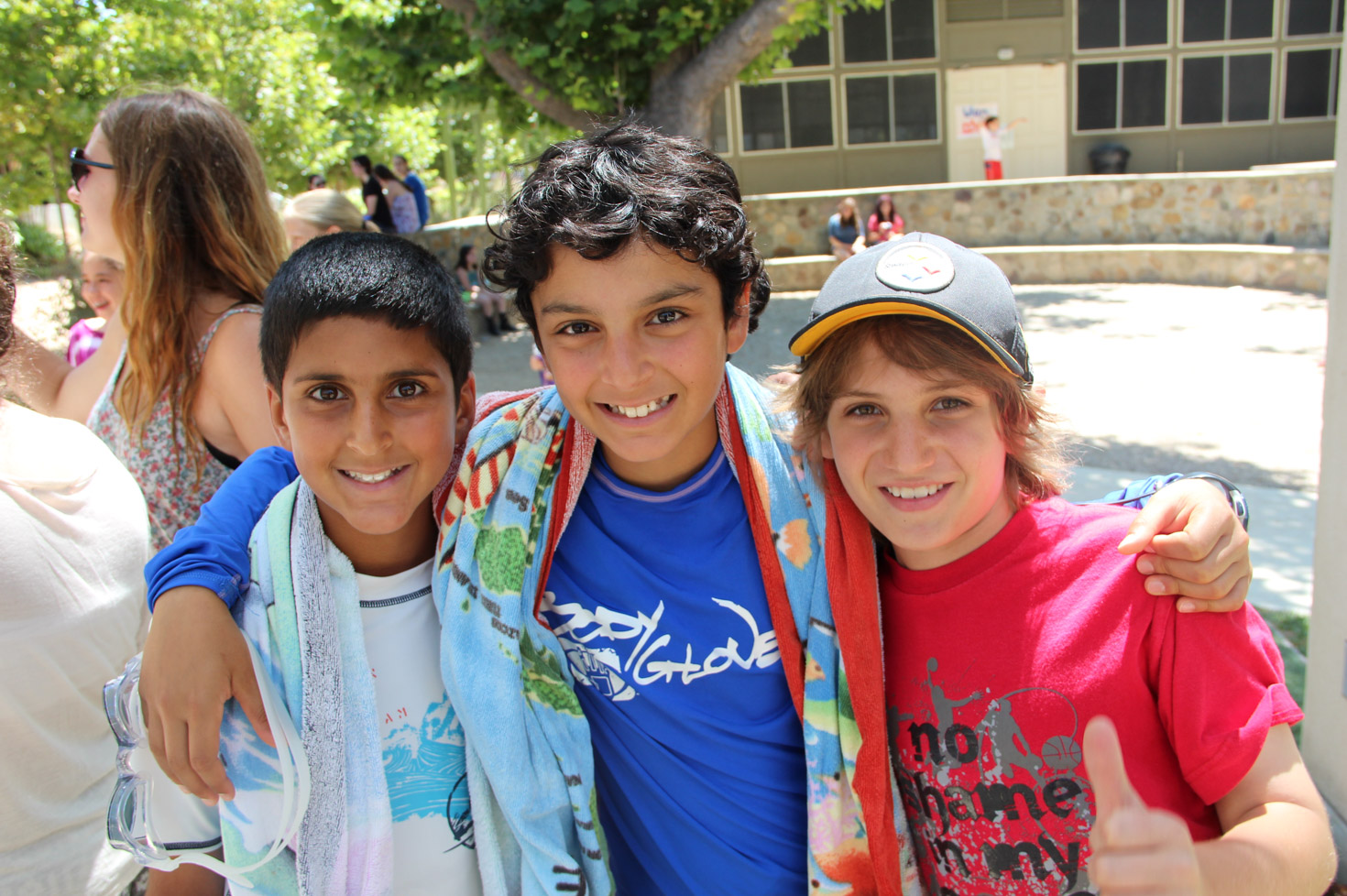 Three camper friends taking a photo with arms around each other outside