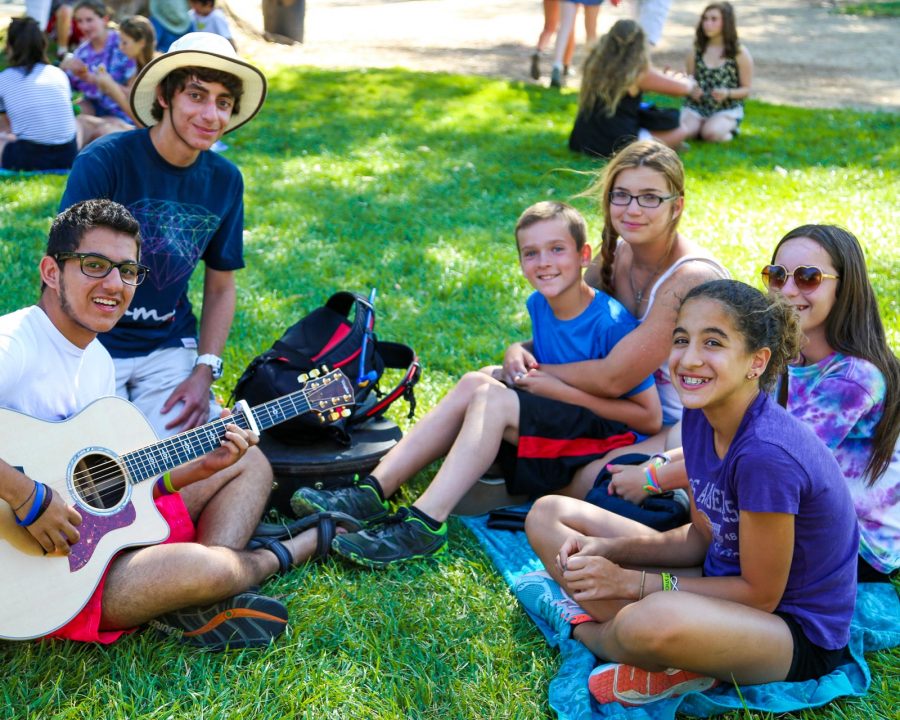 Campers practicing instruments outside on the grass