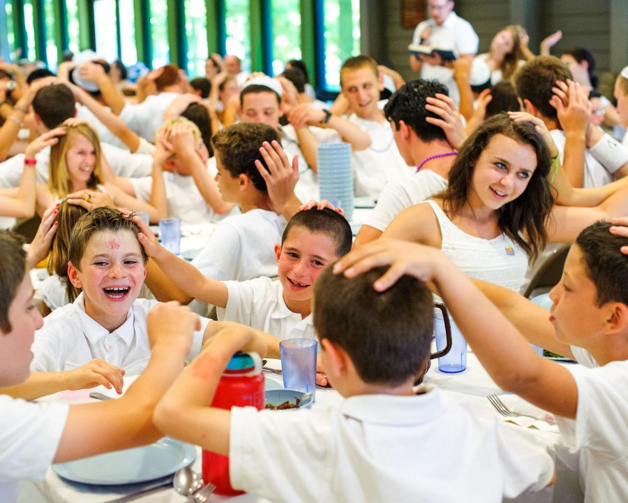 Campers putting hands on their neighbors head