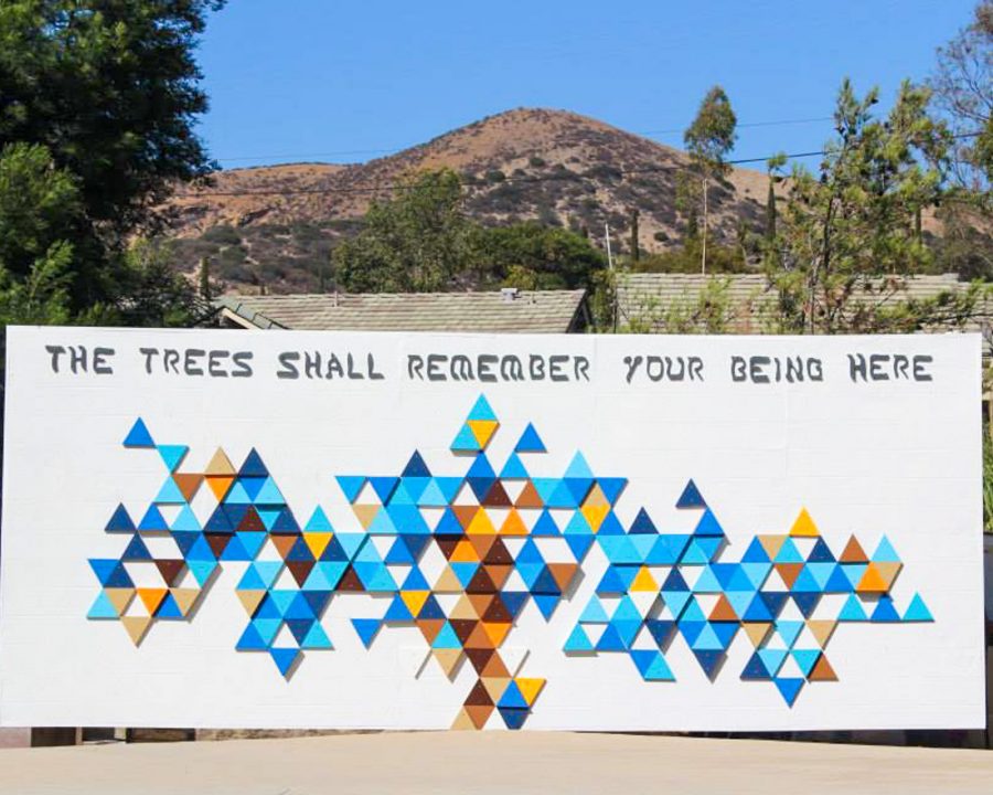 Art mural that says "The trees shall remember your being here"