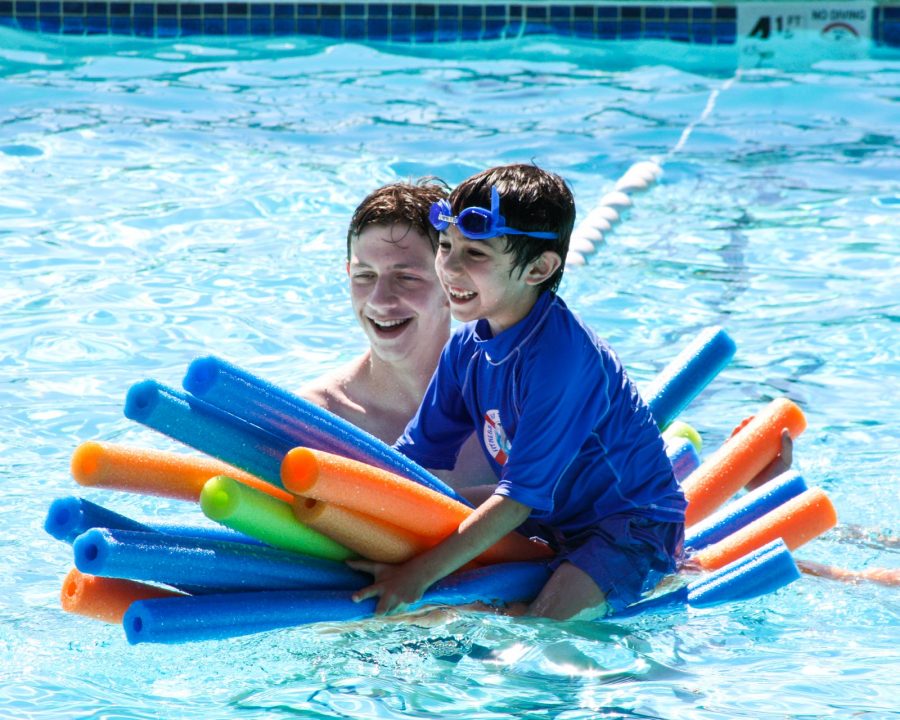 Counselor with a camper in the pool