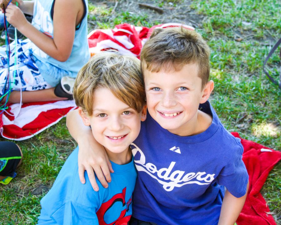 Two young campers taking a photo together on the grass