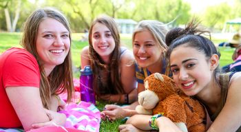 Teen campers smiling together on the grass