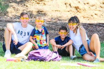 two campers and two counselors with silly glasses on at camp