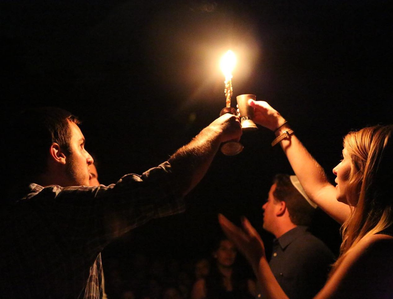 Two Staff Members holding up Havdalah Candle and Kiddush Cup During Havdalah Service