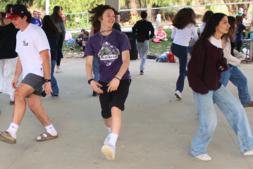 three teens israeli folk dancing in a circle. smiles on faces.